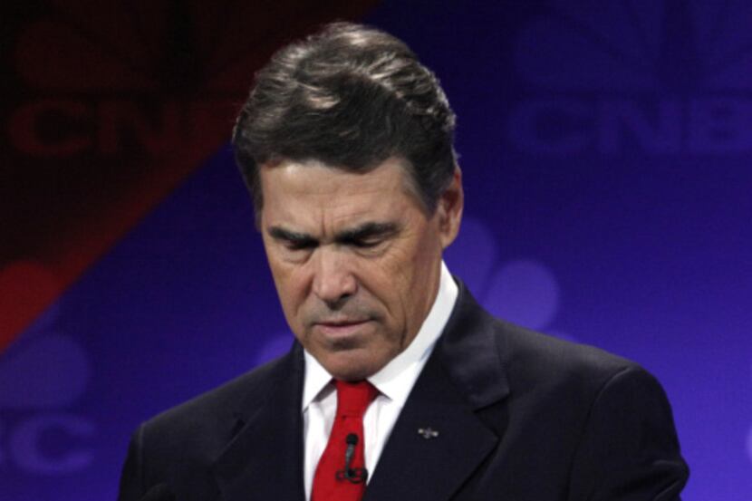 Gov. Rick Perry looked at his notes during a debate at Oakland University in Auburn Hills,...
