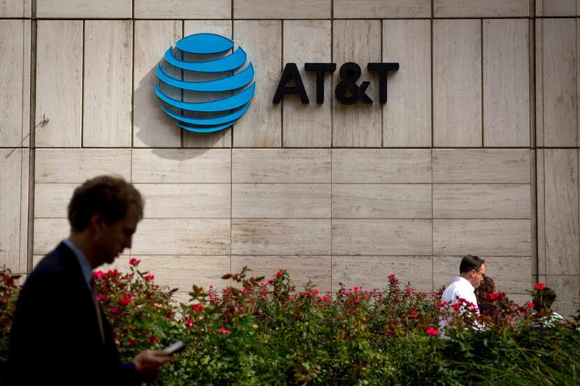 People walk by the front of AT&T's downtown headquarters Tuesday, October 25, 2016 in...