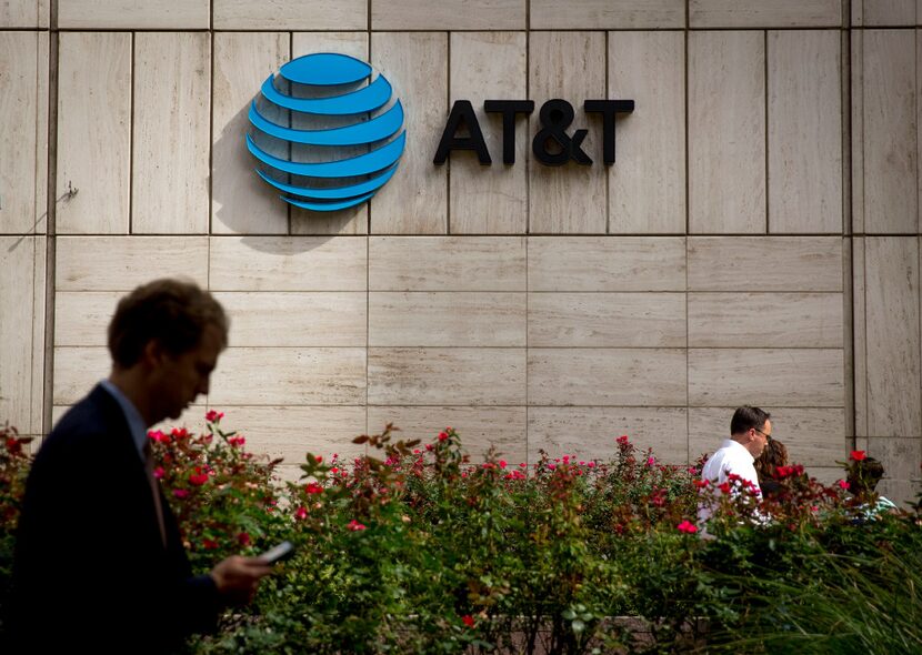 People walk by the front of AT&T's downtown headquarters Tuesday, October 25, 2016 in...