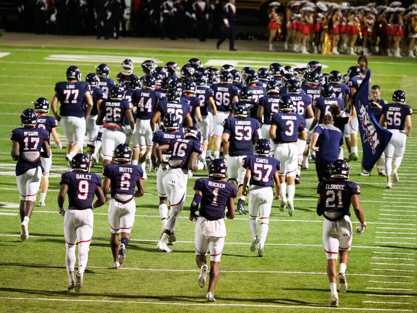 The Ryan High School football team runs out to the field for the second half to play their...