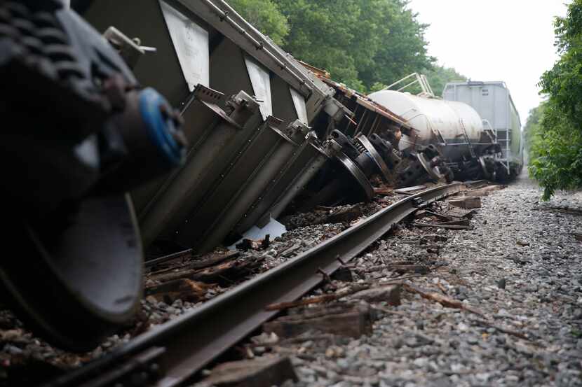 Cars lie tilted off the tracks Wednesday morning after a train derailment Monday night on...