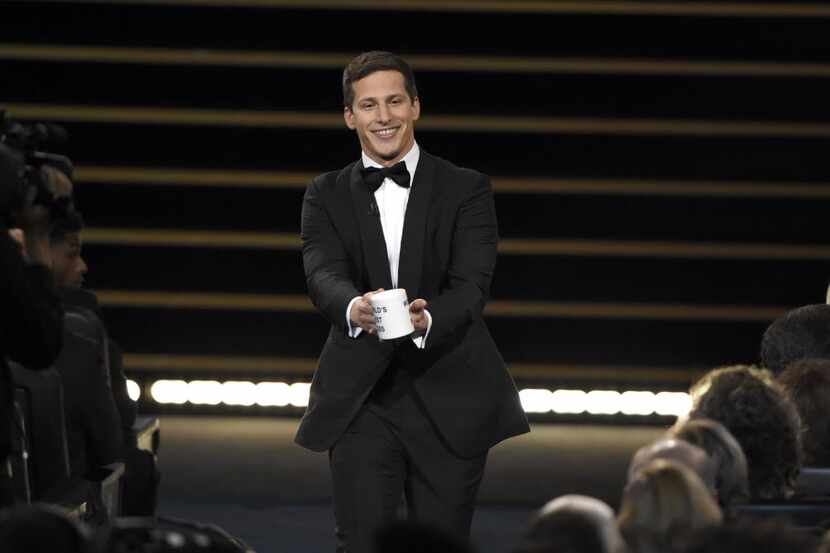 Host Andy Samberg prepares to present a coffee mug to Lorne Michaels at the 67th Primetime...