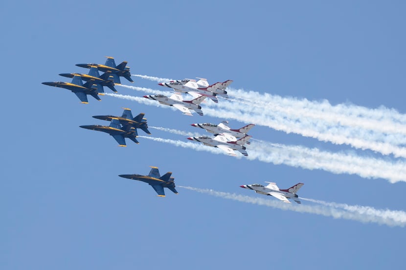 A formation of jets from the Navy's Blue Angels, left, and the Air Force's Thunderbirds fly...