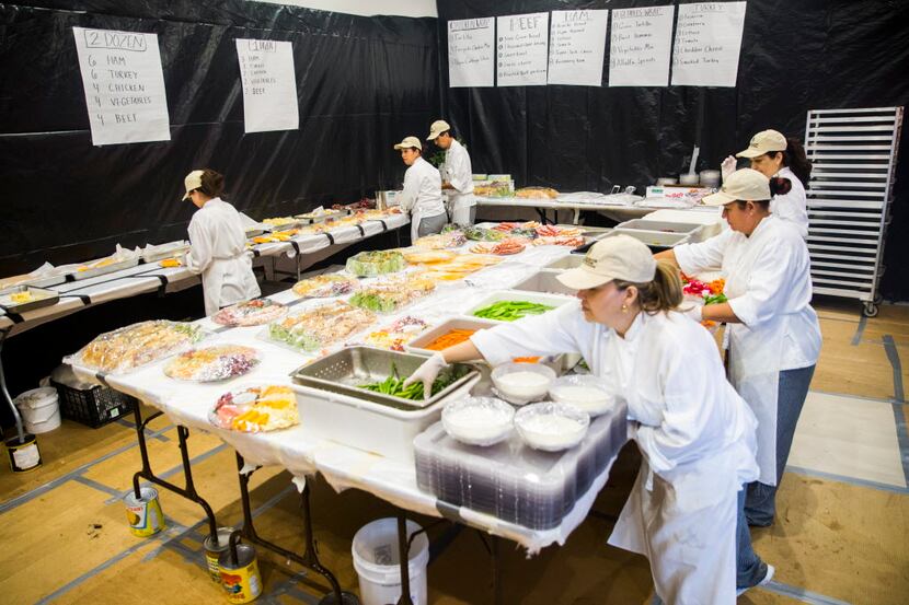 Kitchen staffers assemble cheese and vegetable trays inside the "sandwich room" during round...