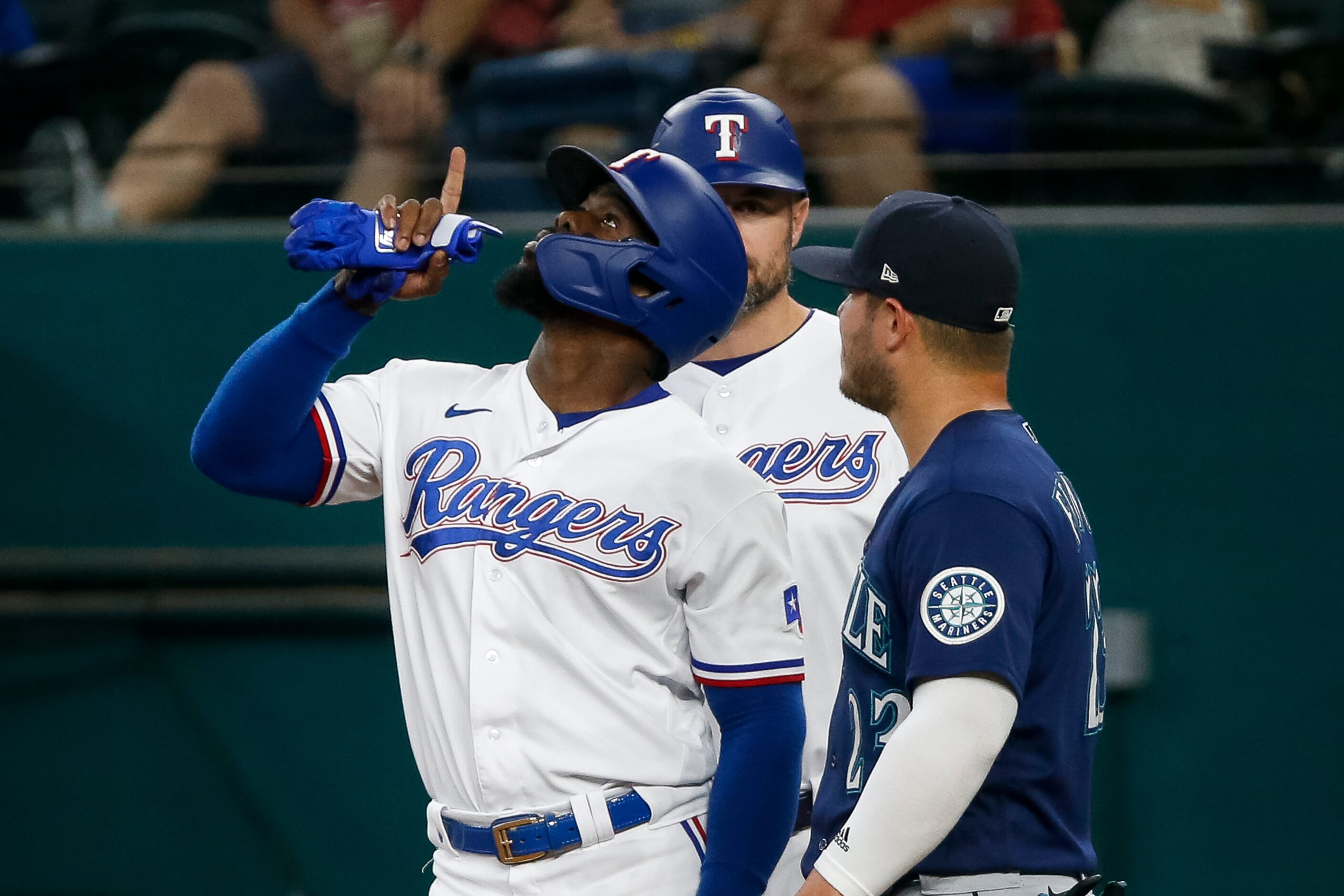 Texas Rangers right fielder Adolis Garcia (53) points skyward after reaching first base on a...