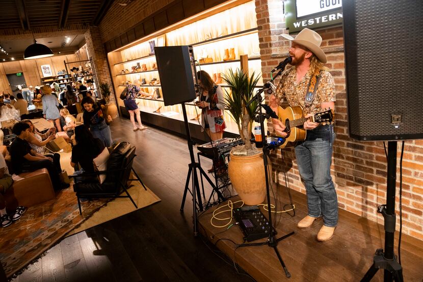 Country singer Trent Walker performs as people browse the store during the opening of the...