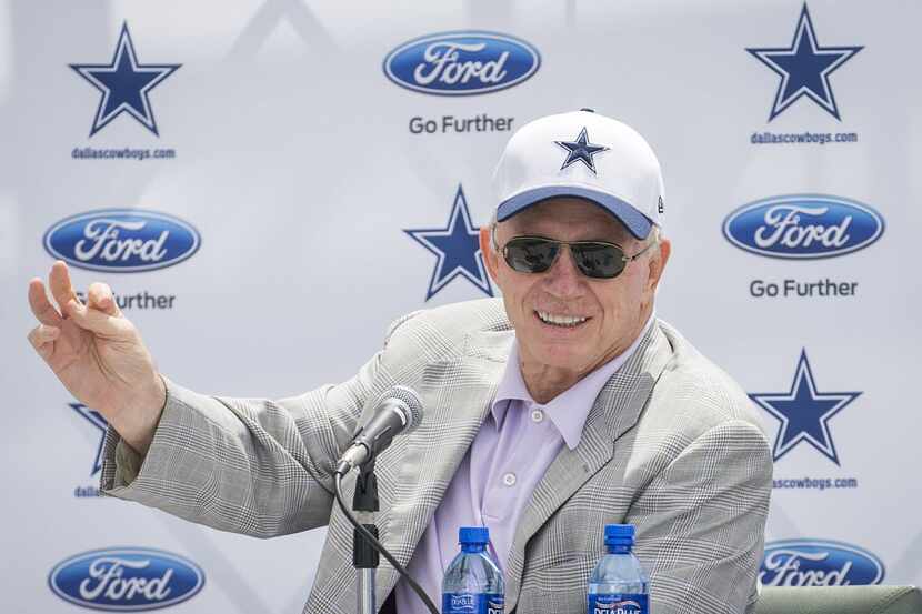 Dallas Cowboys owner Jerry Jones motions with his hand to signify a "tiny violin" playing...