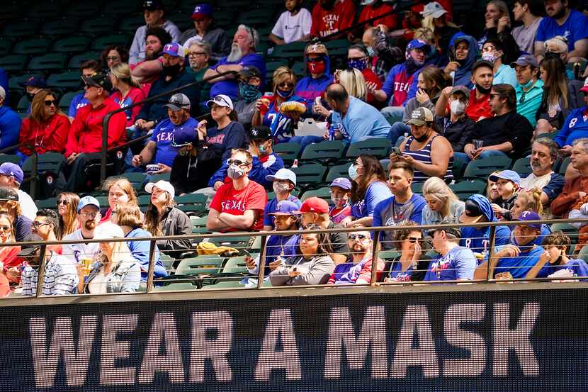 Signs encourage fans to wear face coverings during a game between the Texas Rangers and the...