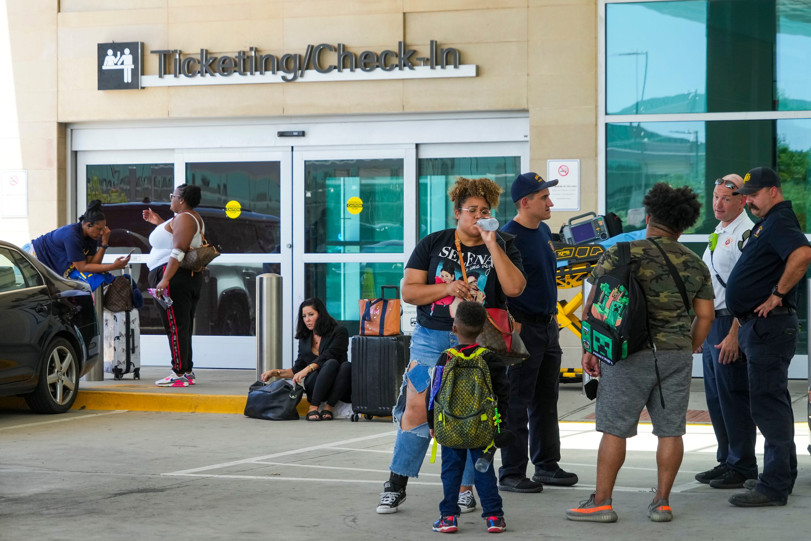 Passengers wait to reenter Dallas Love Field Airport on Monday, July 25, 2022.  A ground...