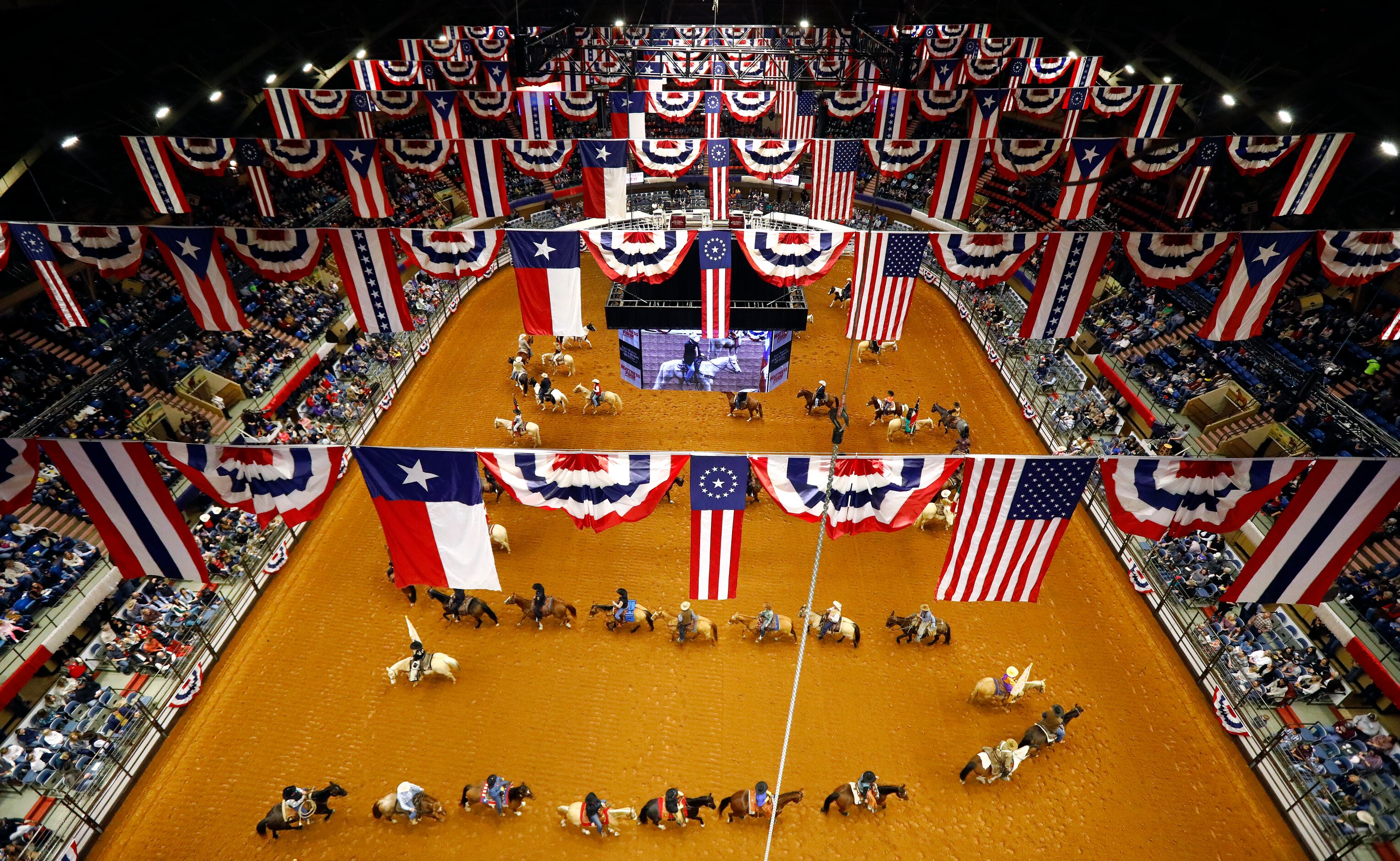 Cowboys, officials and dignitaries on horseback form a serpentine line during the grand...