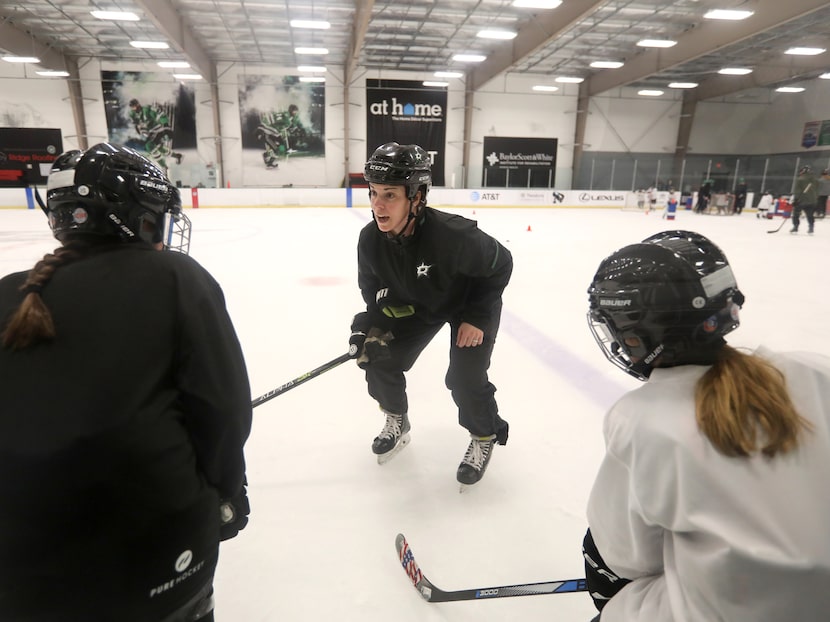 Allysen Weidner demonstrates a proper playing stance to 10-year-old Emma Taylor, left, and...