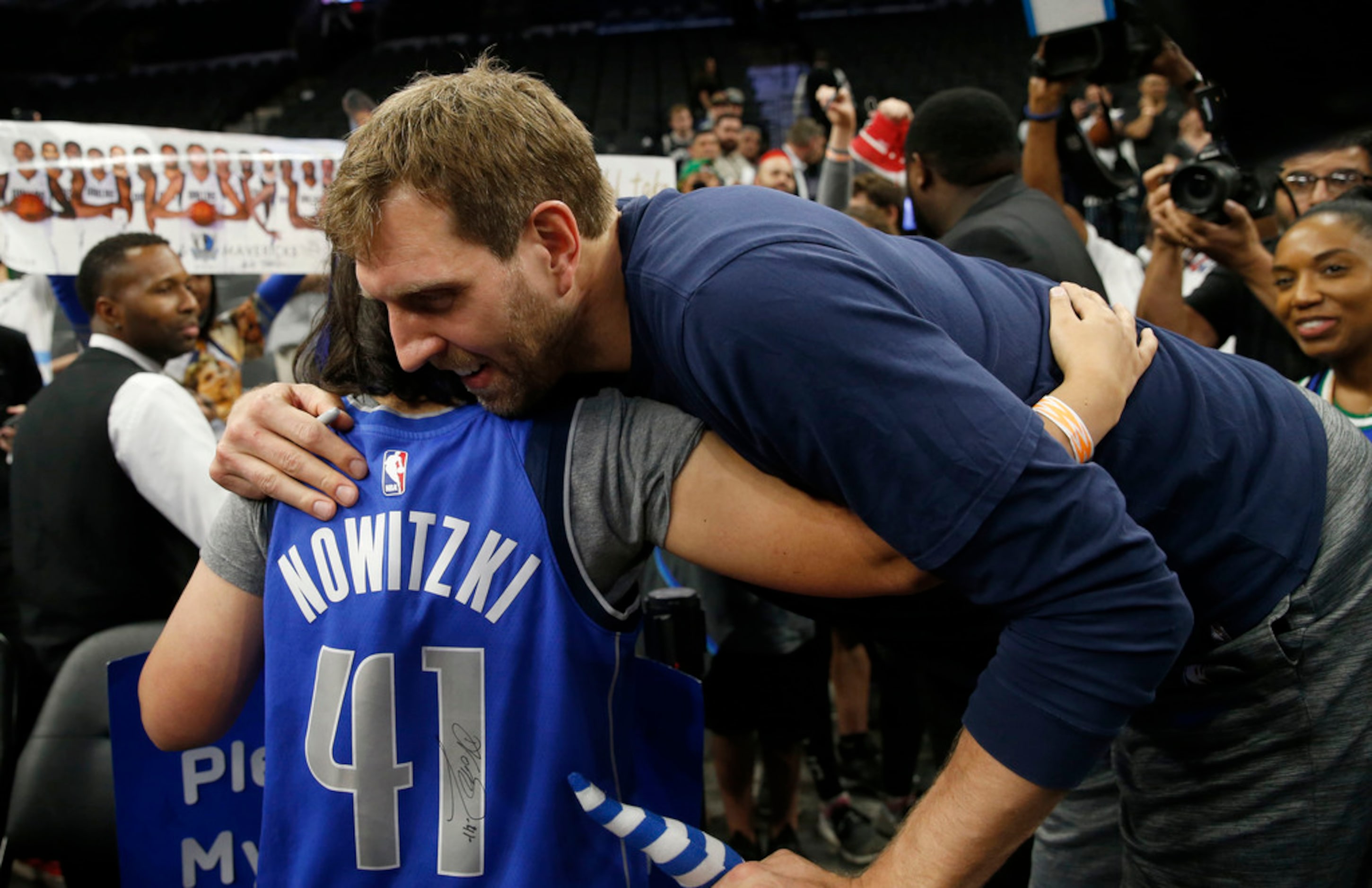 Anna Smedley, 16 of San Antonio, hugs Dallas Mavericks forward Dirk Nowitzki (41) before the...