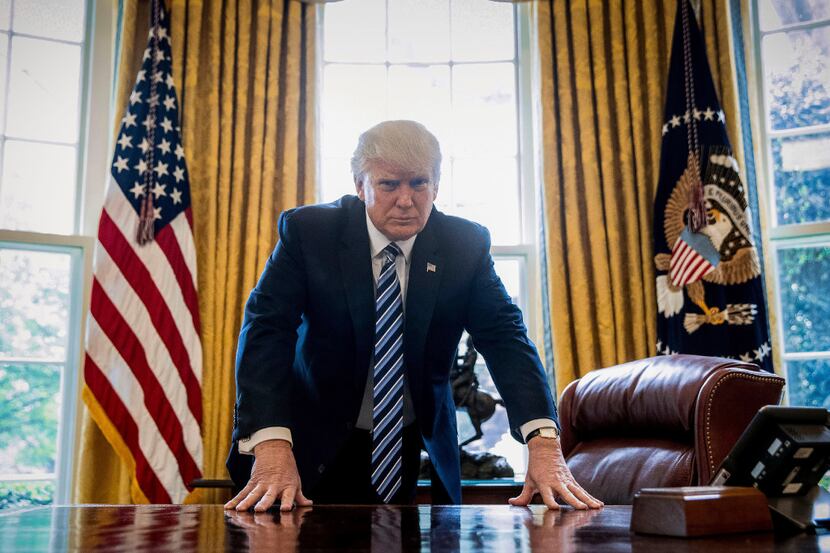 President Donald Trump poses for a portrait in the Oval Office in Washington, Friday, April...