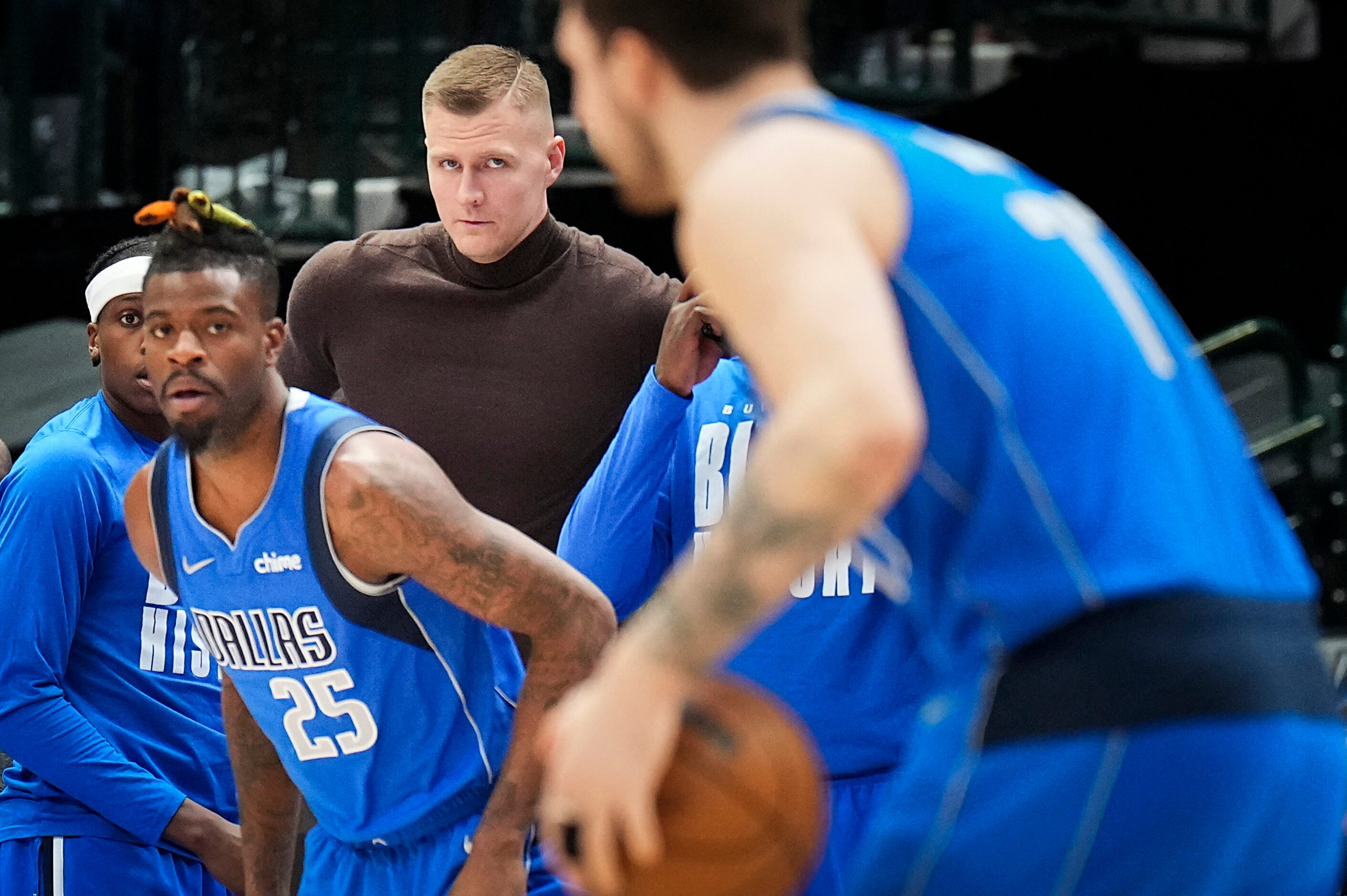 Dallas Mavericks center Kristaps Porzingis watches from the bench as forward Reggie Bullock...