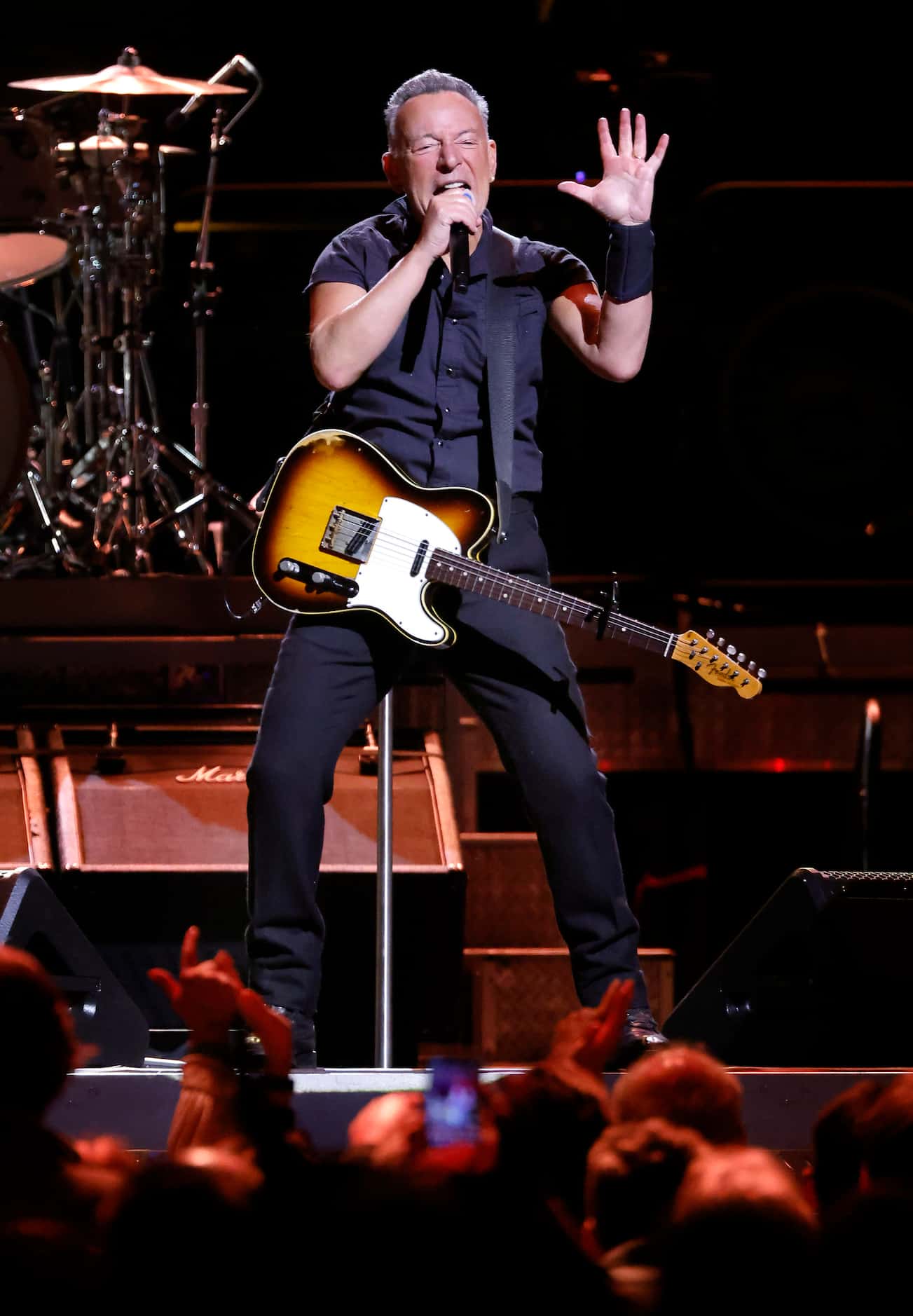 Clad in a black pearl snap shirt and black pants, Bruce Springsteen performed with the E...