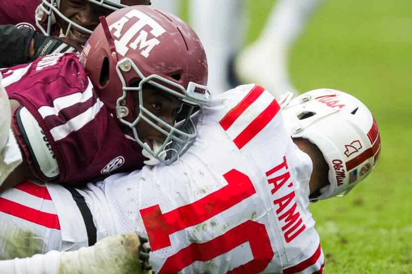 Texas A&M Aggies defensive lineman Justin Madubuike (52) lands on top of Ole Miss Landsharks...