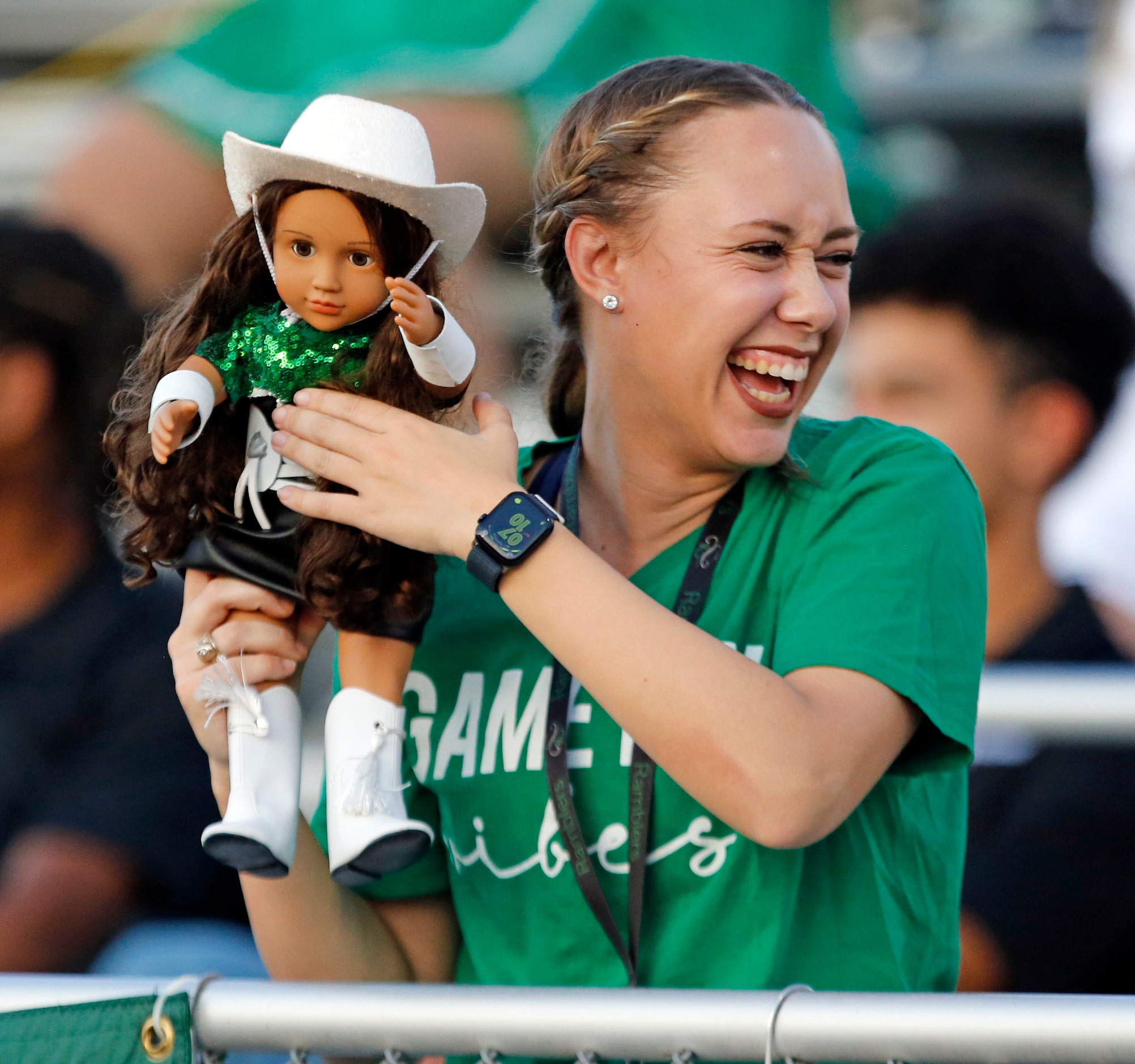 A Richardson Berkner High drill team member play with a doll styled after the drill team...