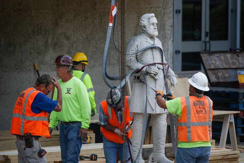 Construction workers move a statue of Robert E. Lee at Dallas' Pioneer Park on Monday.