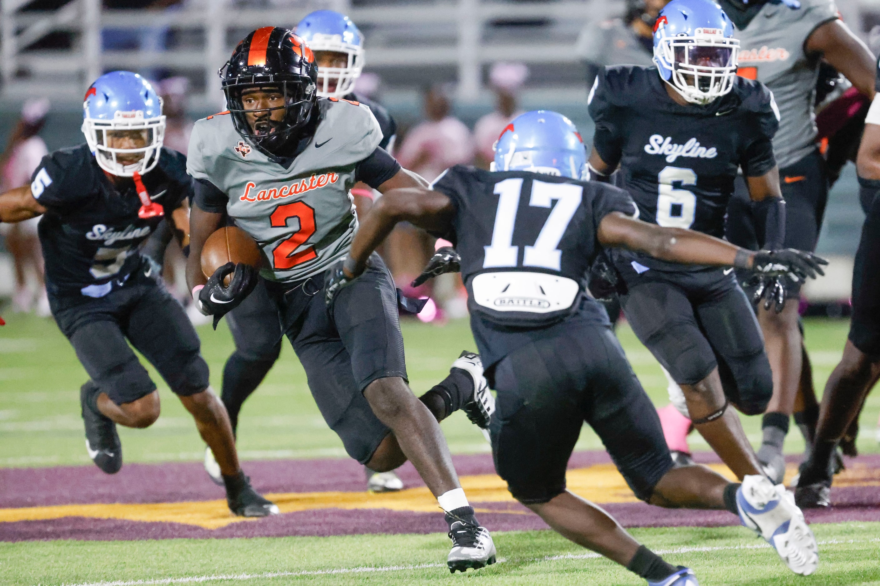 Lancaster High’s Izayah Lee (2) runs the ball for a yardage during the second half of a...