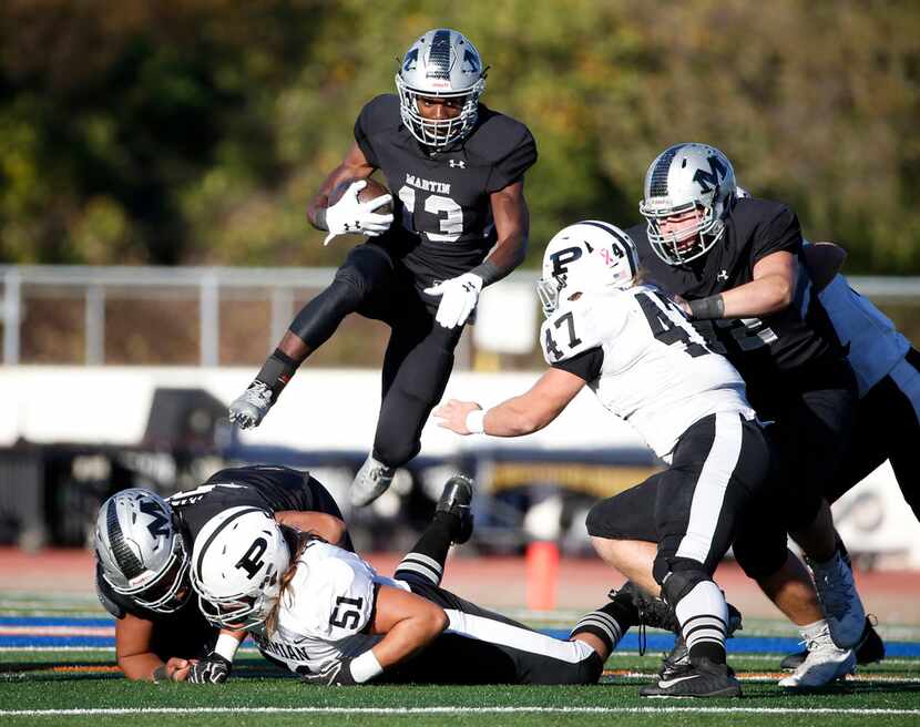 Arlington Martin running back Montrell Smith (13) jumps over a pile during the Class 6A...