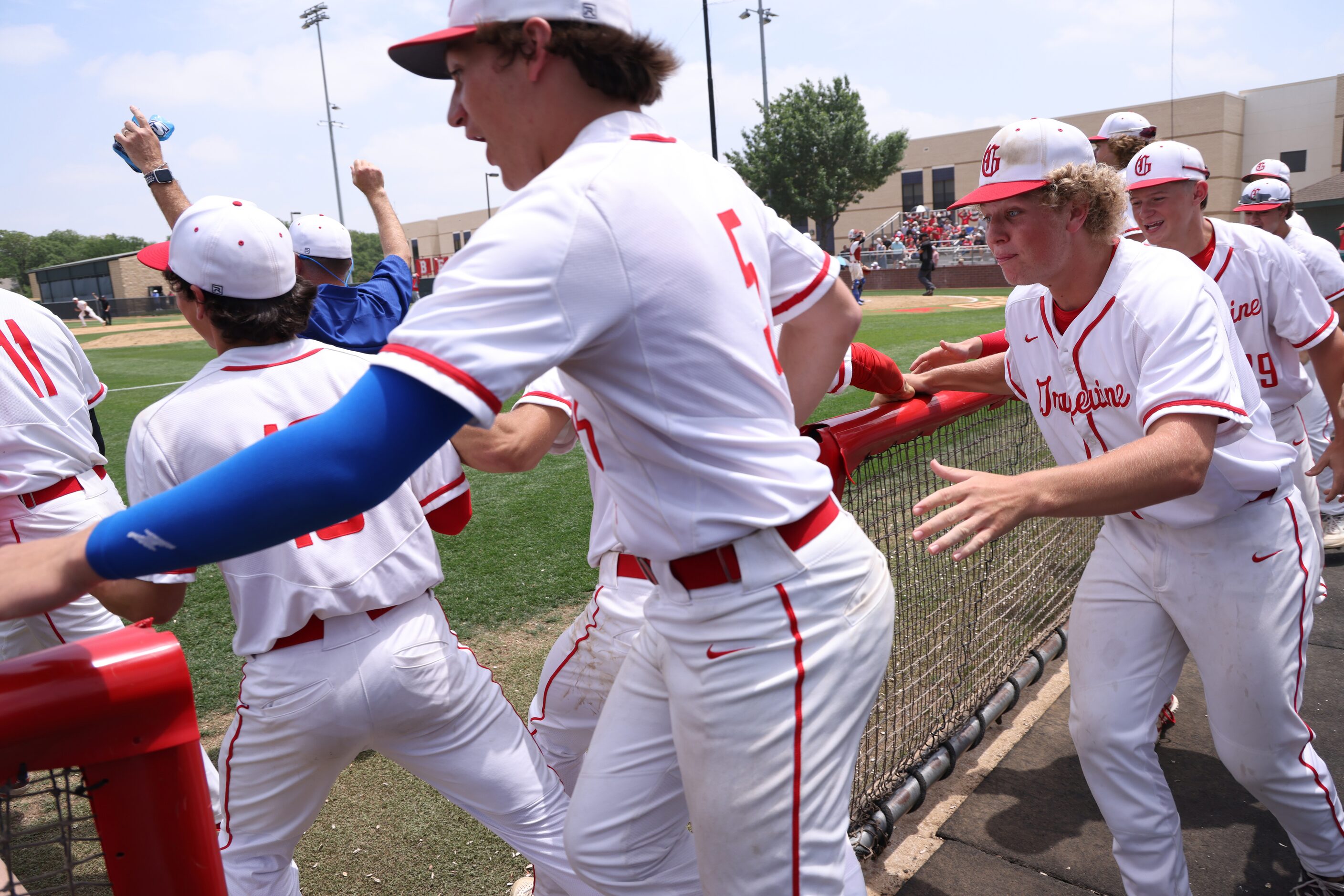 Grapevine players bolt from the team dugout after a diving catch in the outfield sealed a...