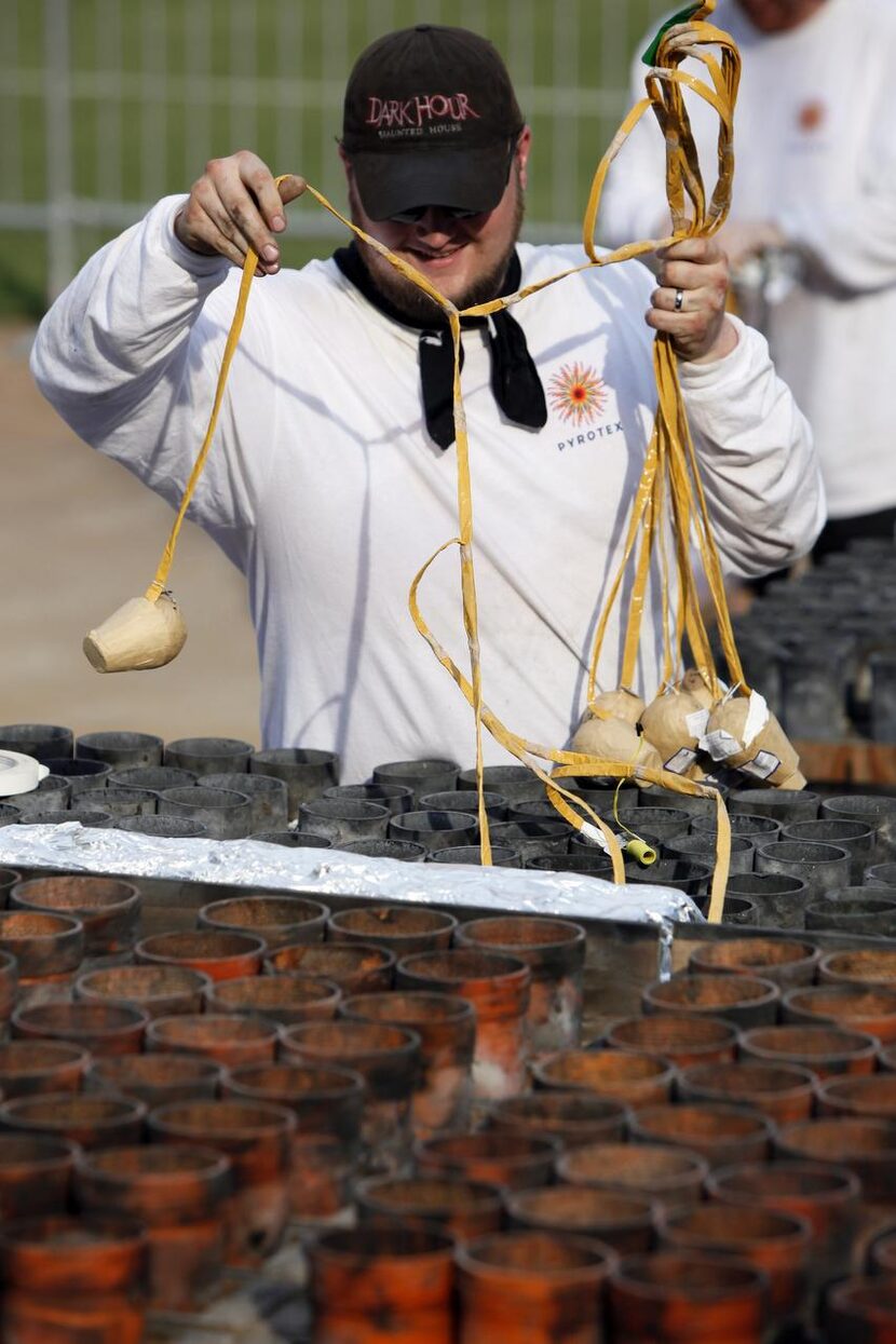 Lead pyro technician Jake Farmer  loads mortar pipes with fireworks during the installation...