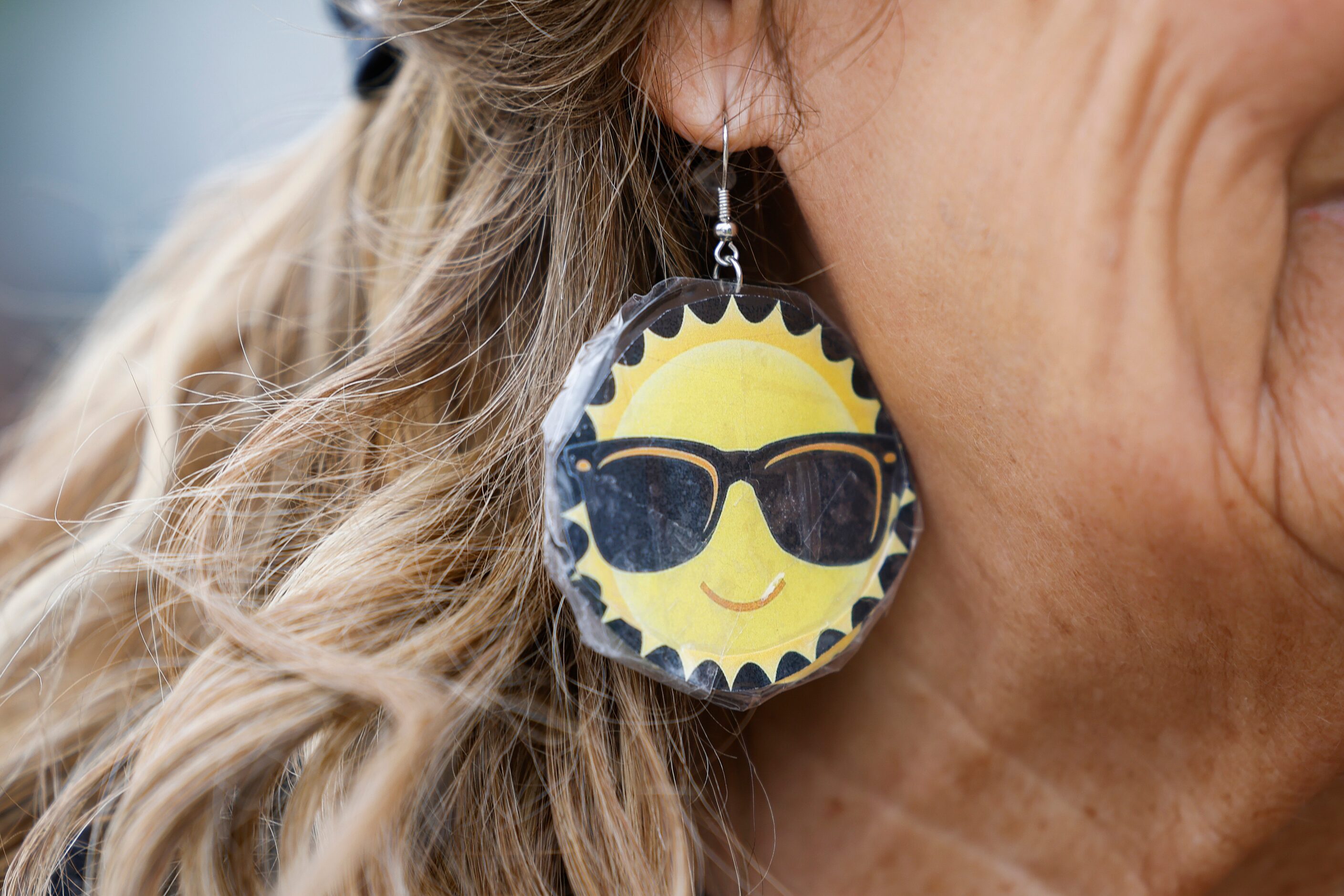 Barbara Tomasino wears sun themed glasses while waiting in line for the Perot Museum of...