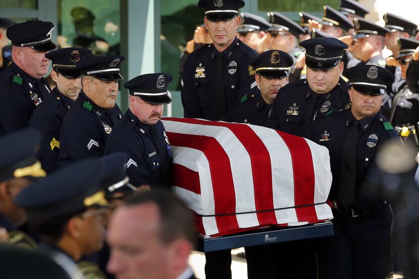 Police pallbearers with the casket of Lorne Ahrens at Prestonwood Baptist Church in Plano on...