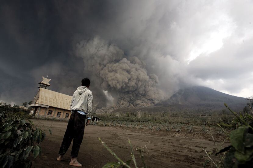 A resident looks  at giant volcanic ash clouds from a village in Karo district during the...