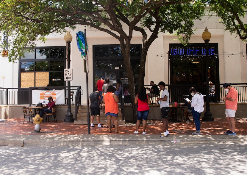 Customers wait in line outside of BurgerIM on Sunday, May 31, 2020 in Dallas. Many in the...