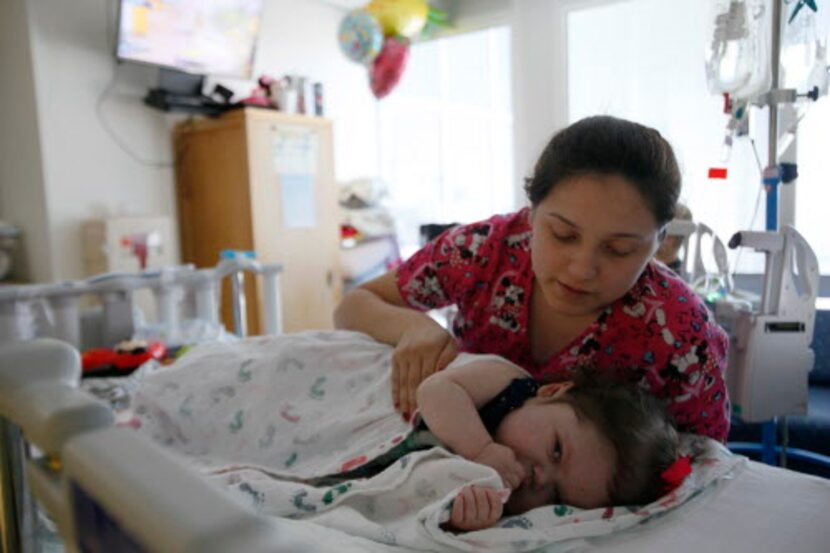 Ana María García intenta dormir a Alissa, meciéndola de una lado al otro. La madre suele...