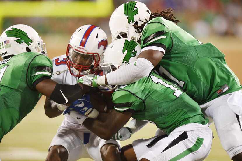 North Texas senior defensive back James Gray (21), senior defensive back Chad Davis (16) and...