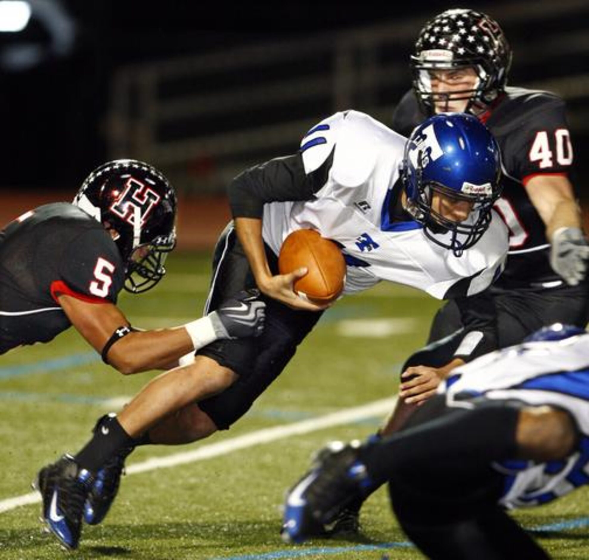 Rockwall-Heath defenders Jovan Hernandez (5) and David Tanner (40) tackle Carrollton R.L....