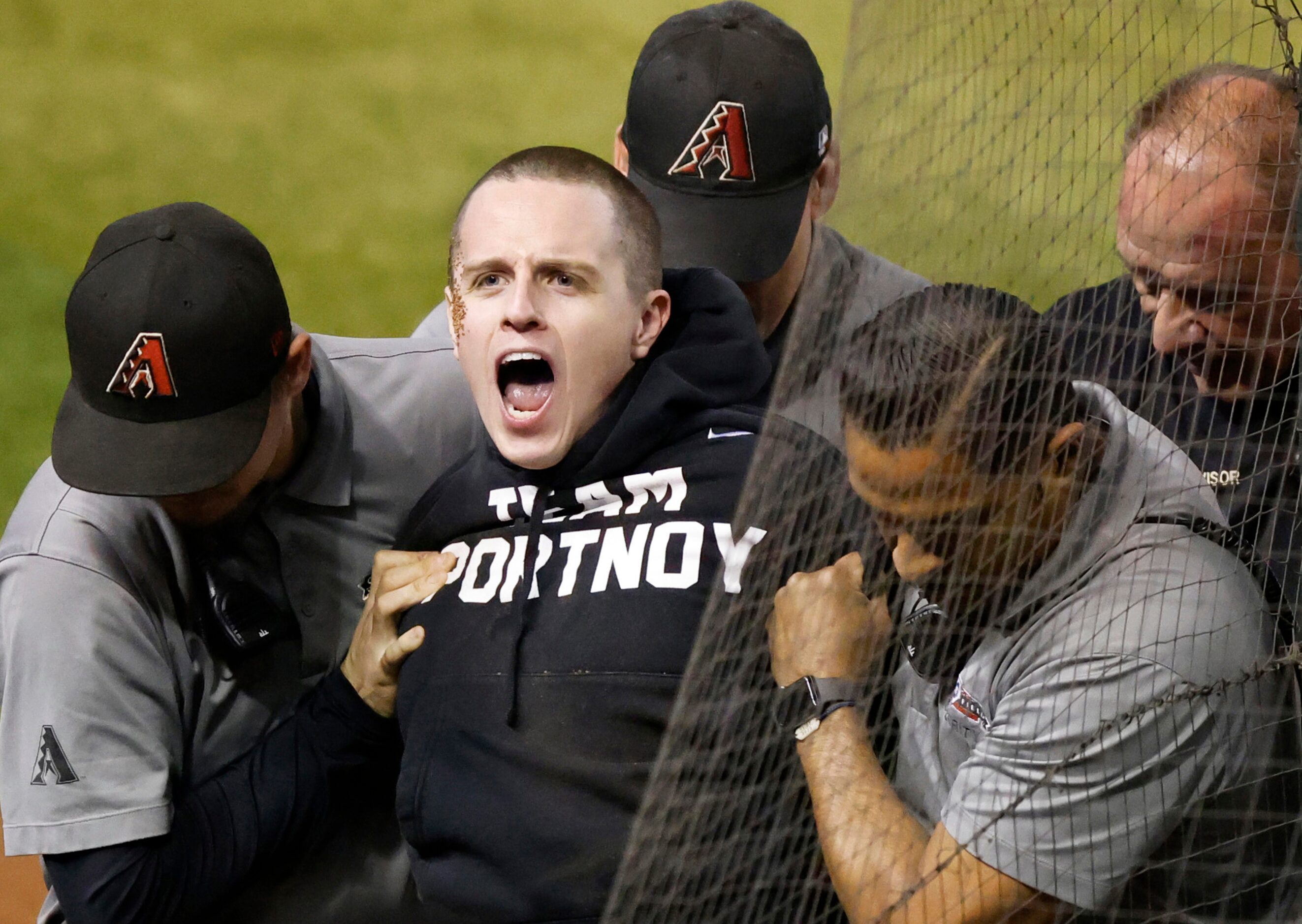 Security apprehends a fan who ran onto the field during Game 4 of the World Series between...