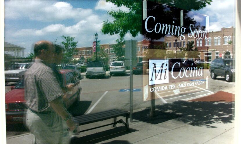 Steve Stanley, left, and Shawn Keegan, right, are reflected in the window where Mi Cocina...