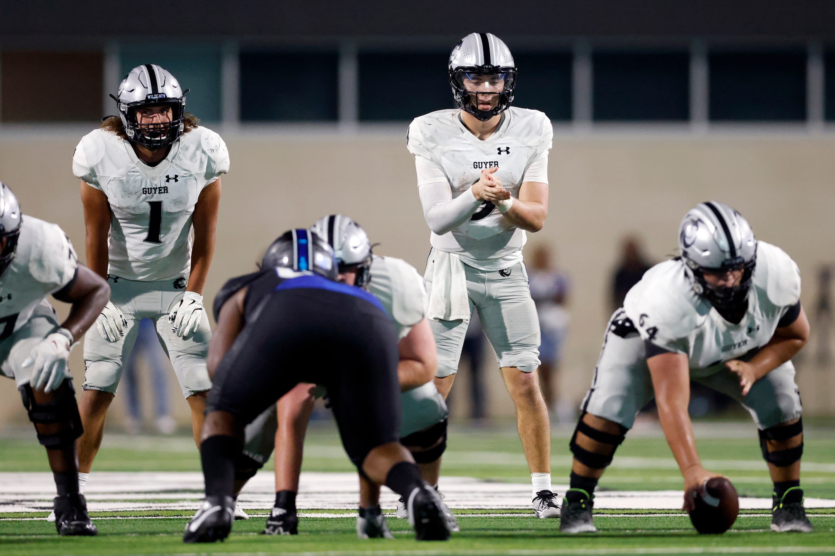 Denton Guyer quarterback Kevin Sperry (9) waits to take the snap from center Adriano Nevarez...