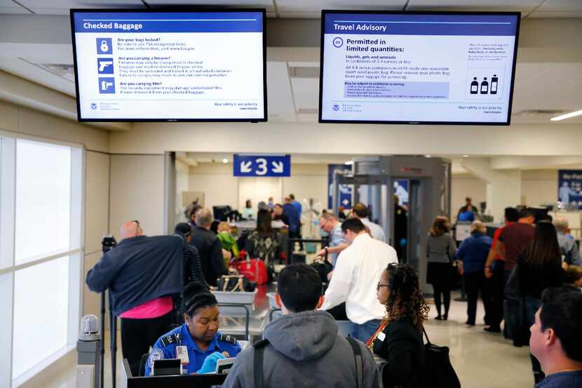 Video screens remind airline passengers about what items cannot be taken through the TSA...