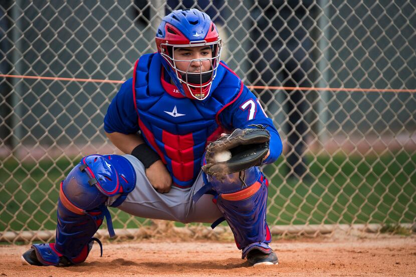 Texas Rangers catcher Jose Trevino catches in the bullpen during the first spring training...