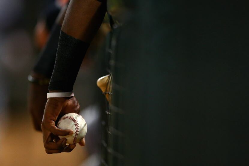 Nov 2, 2013; Surprise, AZ, USA; Detailed view of a player holding a baseball in the dugout...