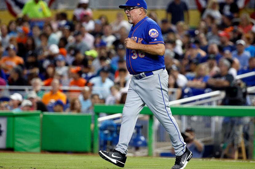 FILE - In this April 16, 2017, file photo New York Mets pitching coach Dan Warthen heads to...
