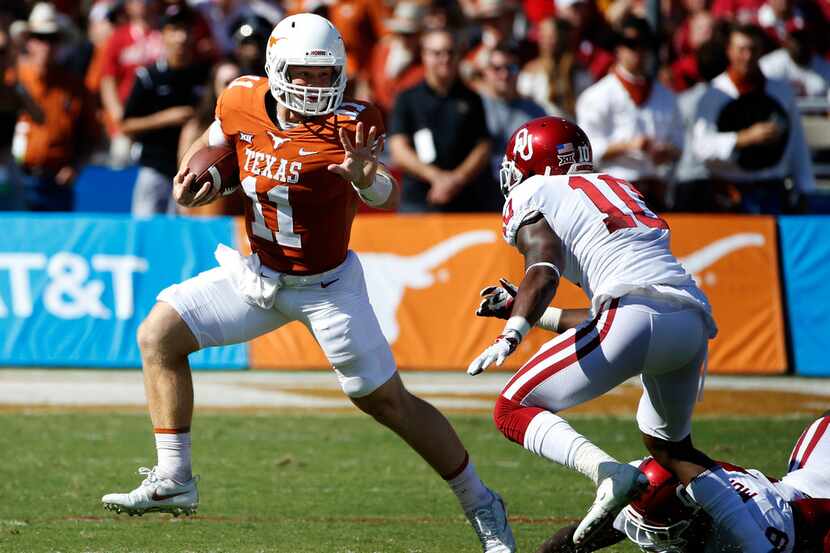 FILE - In this Oct. 14, 2017 file photo, Texas quarterback Sam Ehlinger (11) tries to get...