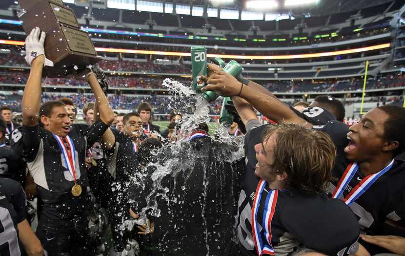 Denton Guyer's Preston Thrailkill (15) and Ellis Jefferson (19) douse head coach John Walsh...