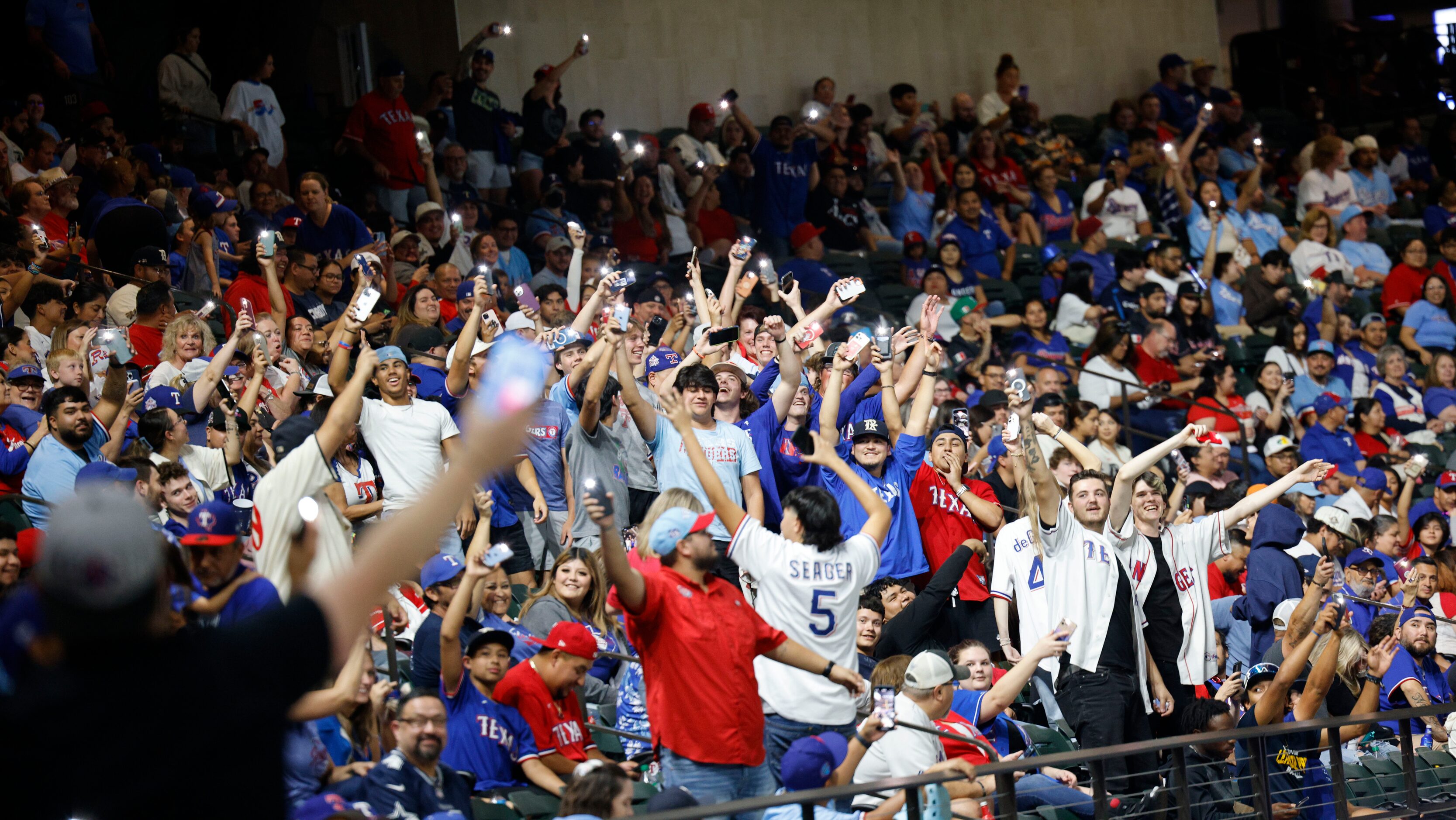 Texas Rangers fans wave their cellphones during a Game 7 watch party of the baseball...