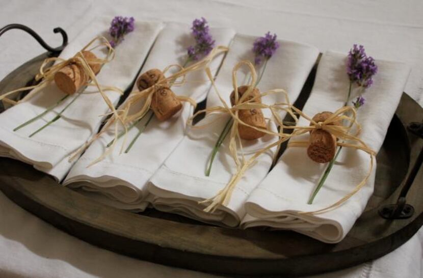
Folded napkins for a dinner party, tied with raffia, a champagne cork and lavender 
