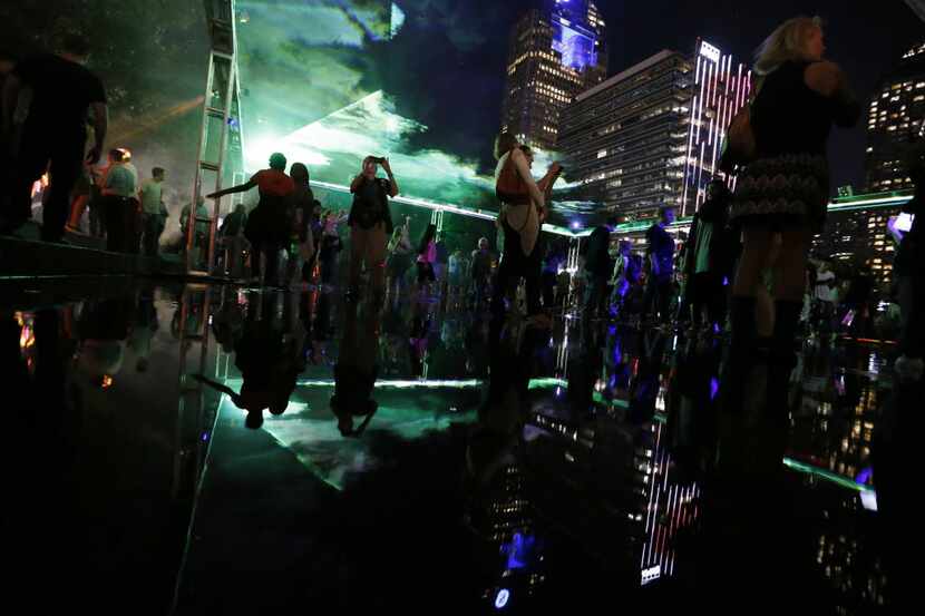 People take in the sights in the Dallas Arts District during Aurora on Friday, October 16,...