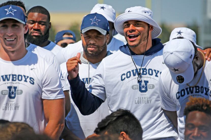 Dallas Cowboys quarterback Dak Prescott, second from right, shares a laugh with teammates,...