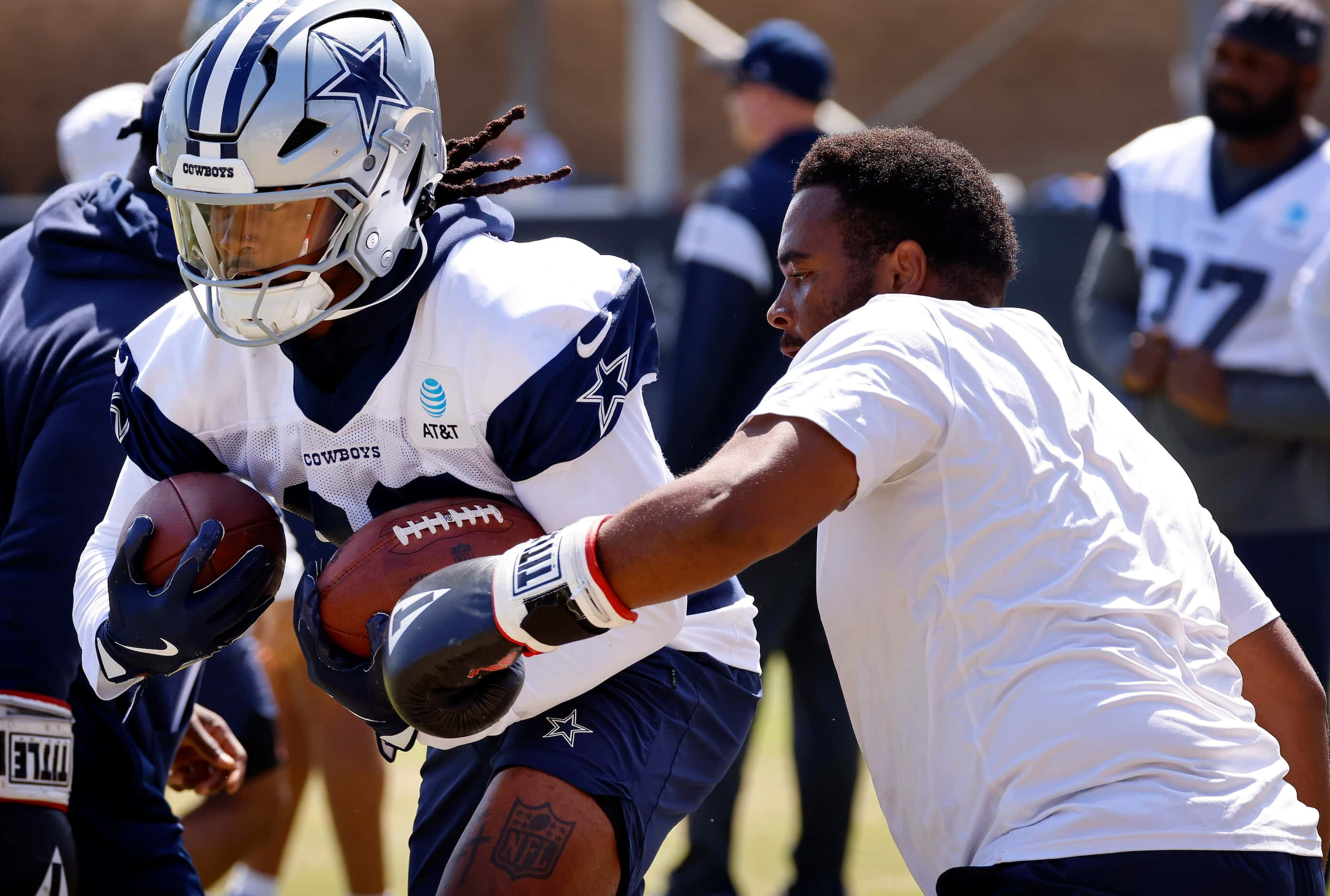 Carrying a pair of footballs, Dallas Cowboys running back Rico Dowdle (23) is pounded with...