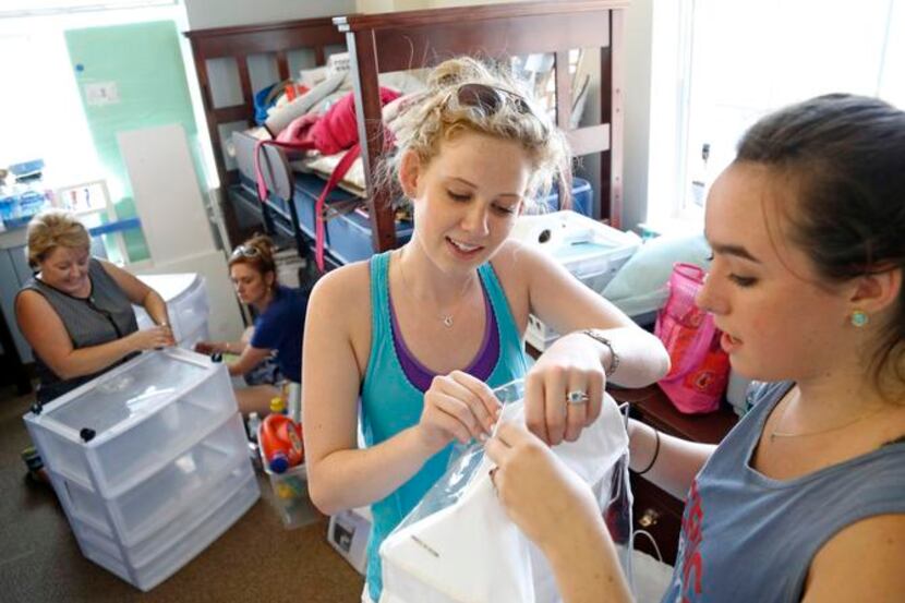 
Dorothy Oehmler (center) and Kaitlyn Waggoner work on a shoe rack in Ware Commons as moms...