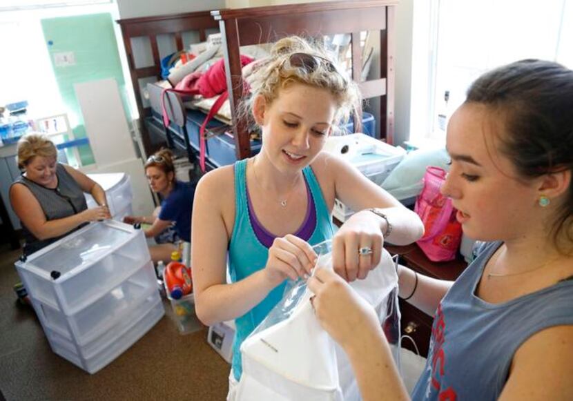 
Dorothy Oehmler (center) and Kaitlyn Waggoner work on a shoe rack in Ware Commons as moms...