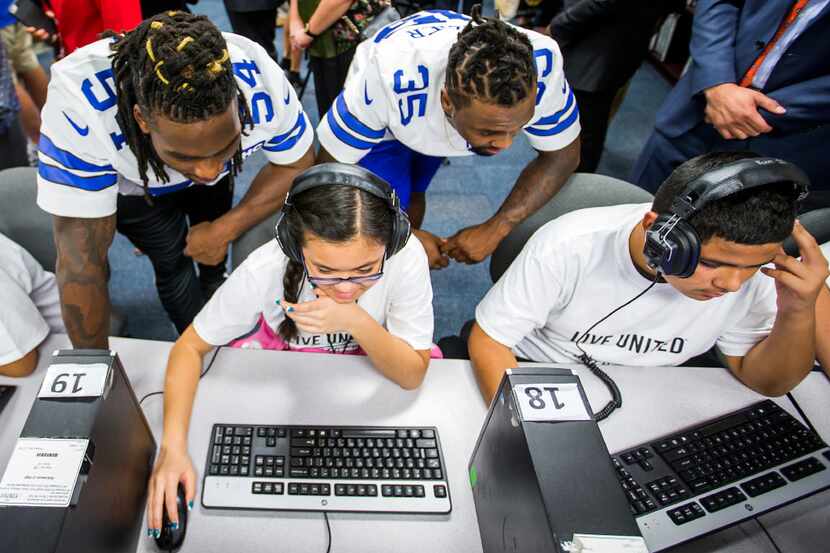 Dallas Cowboys linebacker Jaylon Smith (54) and safety Kavon Frazier work with students in a...